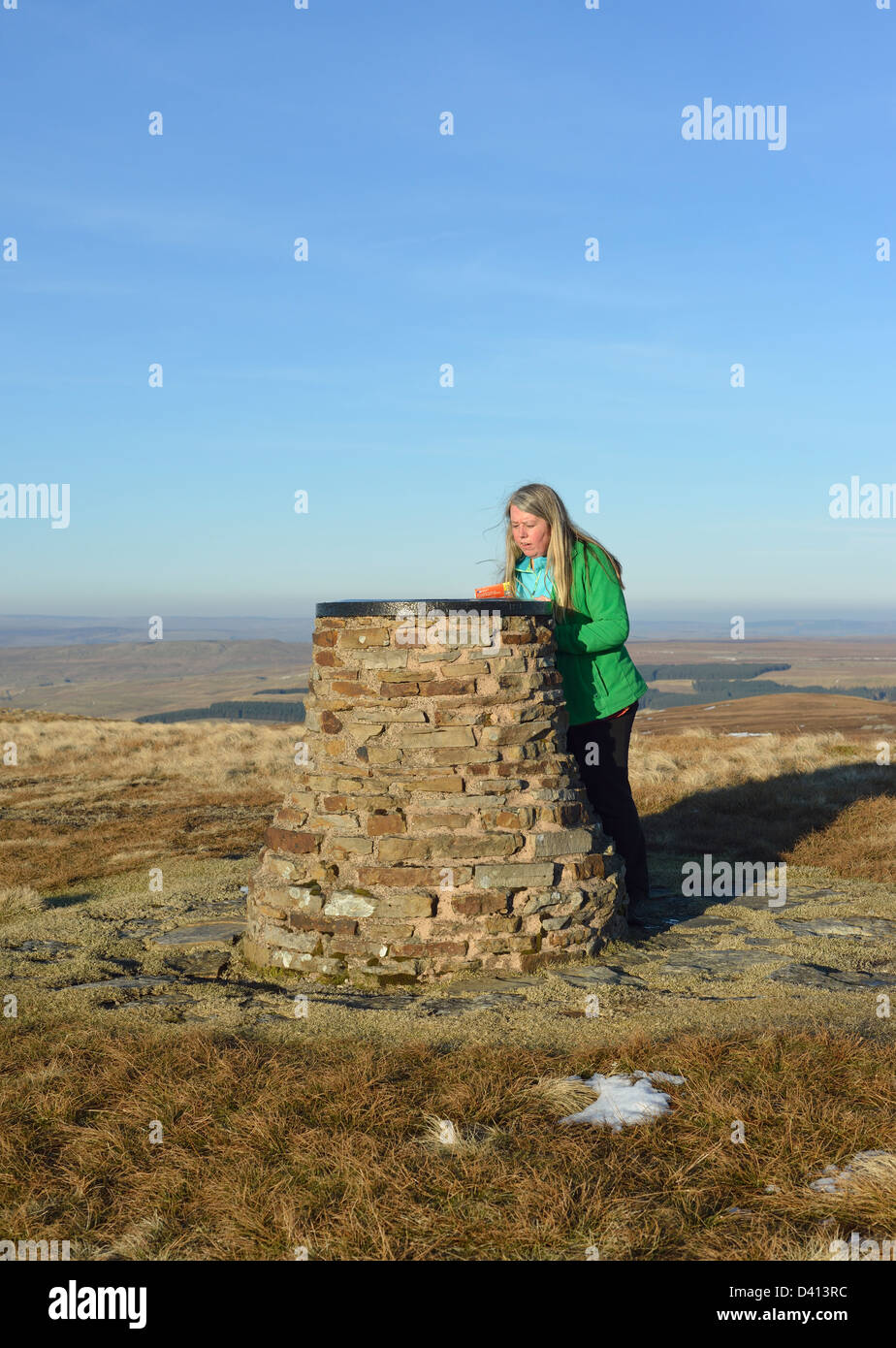 Walker mit O.S Karte am Aussichtspunkt Cairn. Hartley fiel, Cumbria, England, Vereinigtes Königreich, Europa. Stockfoto