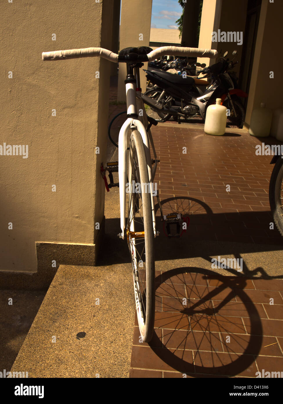 Ein weißes Fahrrad geparkt auf einer Säule Stockfoto