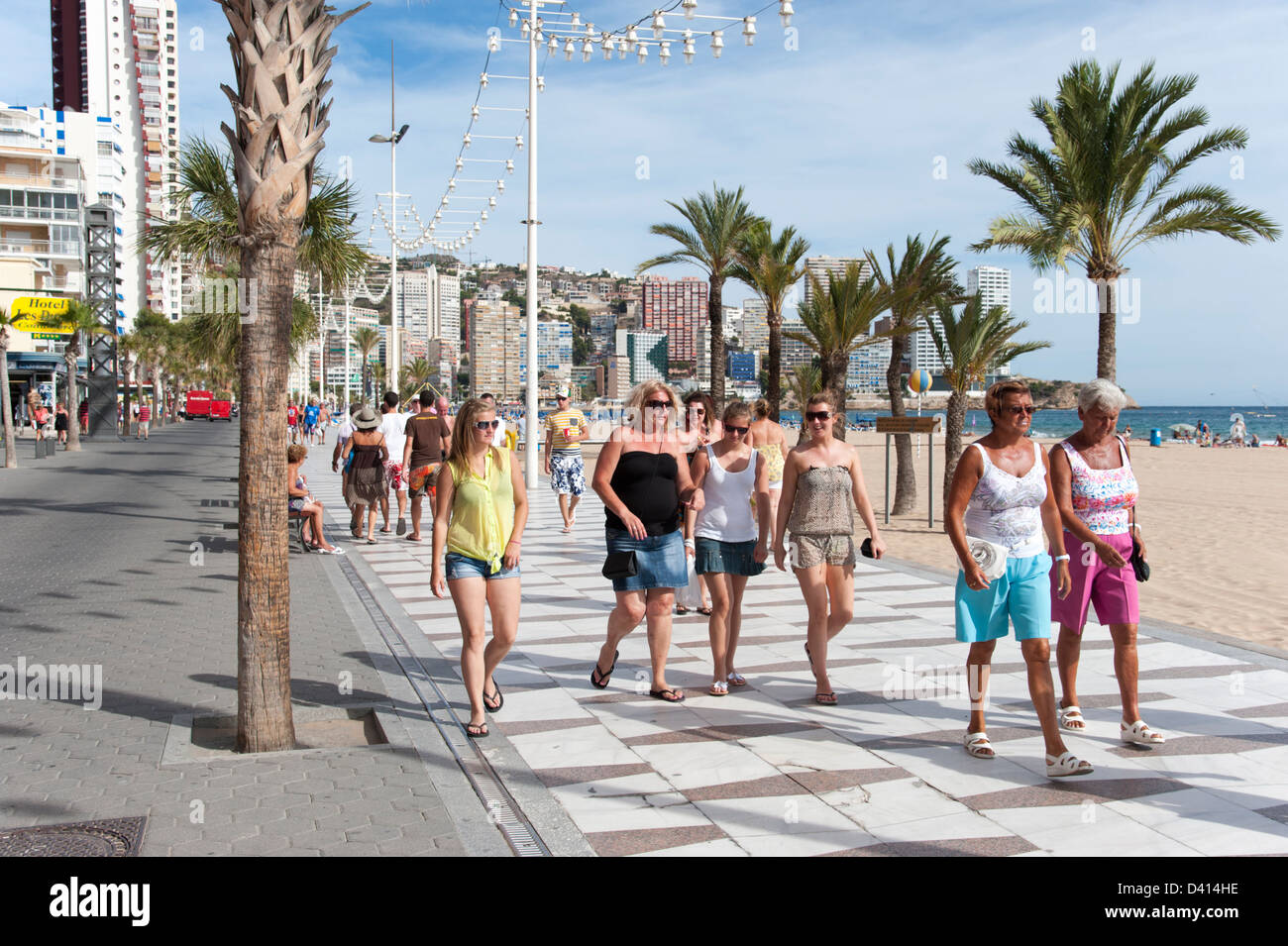 Britische Touristen bummeln entlang der Promenade, Benidorm, Costa Blanca, Spanien Stockfoto