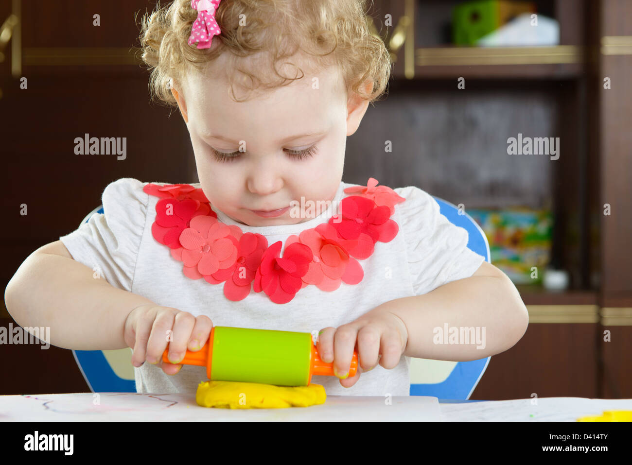 Niedliche kleine Mädchen Lehm Teig mit Nudelholz Rollen Stockfoto