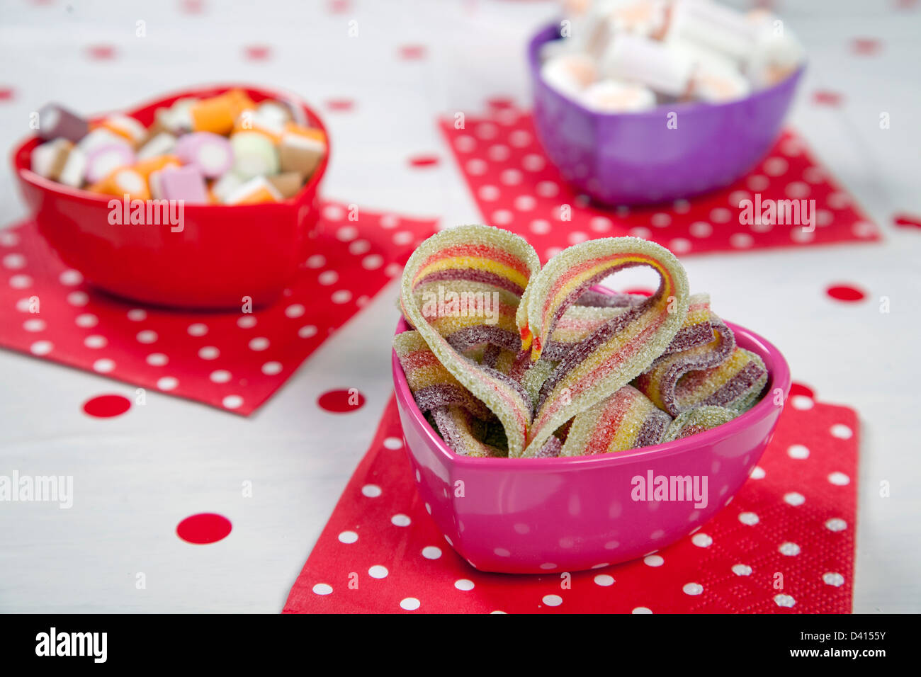 Drei Liebe herzförmige Schalen mit verschiedenen Süßspeisen in ihnen in einer Kinder-Party einstellen Stockfoto