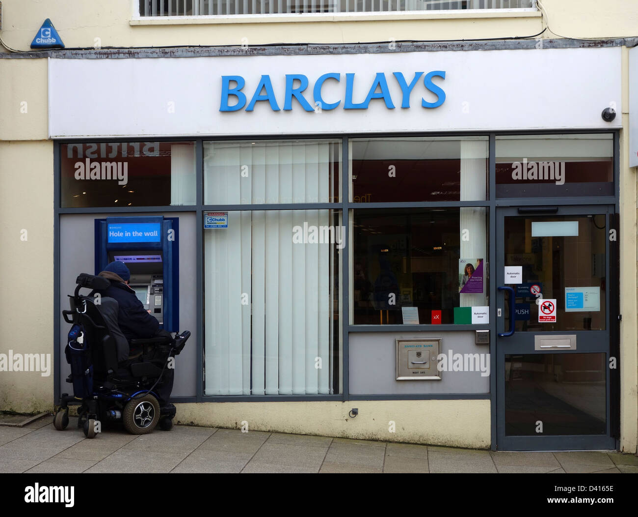 Eine behinderte Kunden mit Hilfe der atm bei einer Barclays Bank Stockfoto