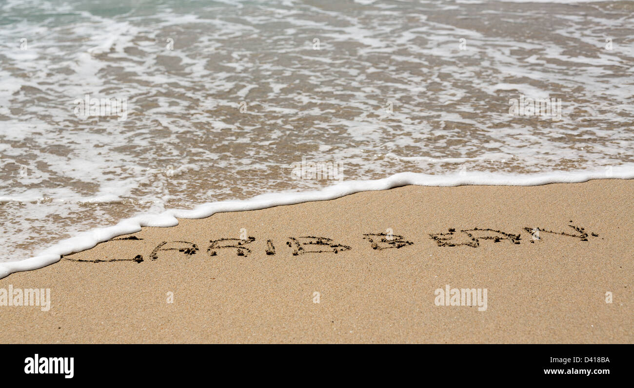 Karibische Worte geschrieben in Sand am Strand vom Meer in St. Thomas Stockfoto