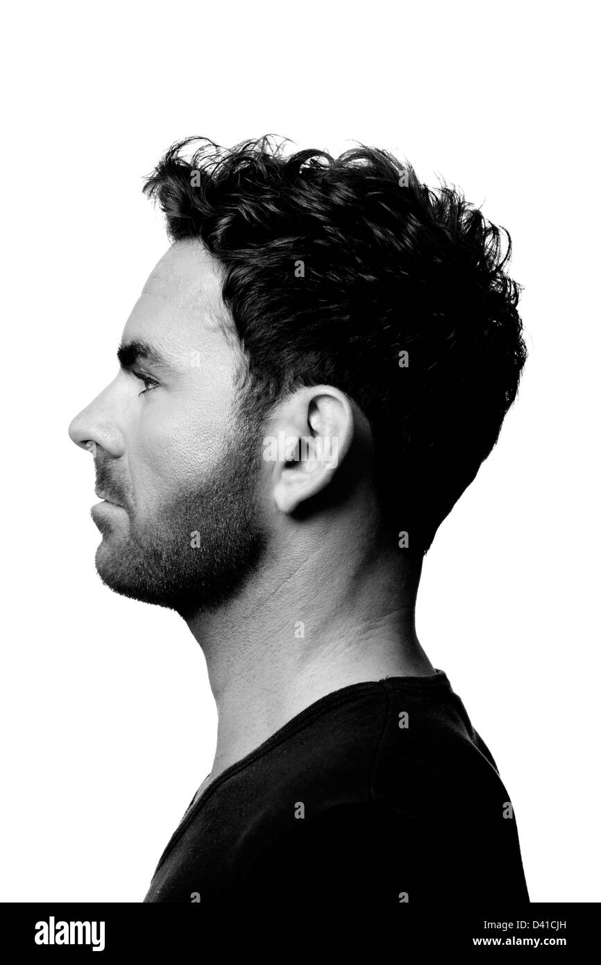 gut aussehend kaukasischen Männermodel eine eng anliegende schwarze V Hals-t-Shirt tragen. Er hat Haare im Gesicht und eine gestylte Frisur. Stockfoto