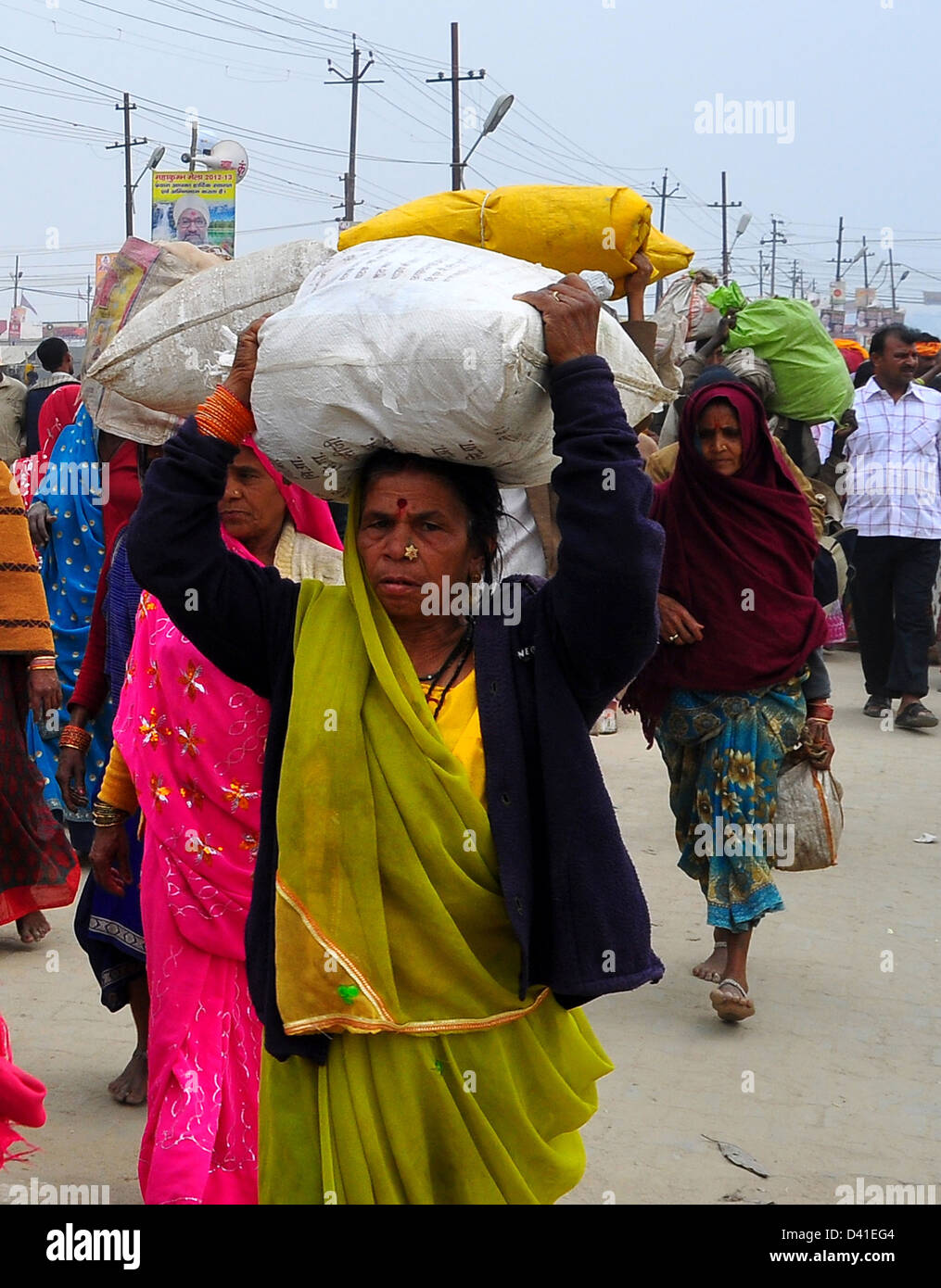 Hindu Anhänger tragen ihre Habseligkeiten auf ihren Köpfen, beim Verlassen der Kumbh Mela in Allahabad Stockfoto
