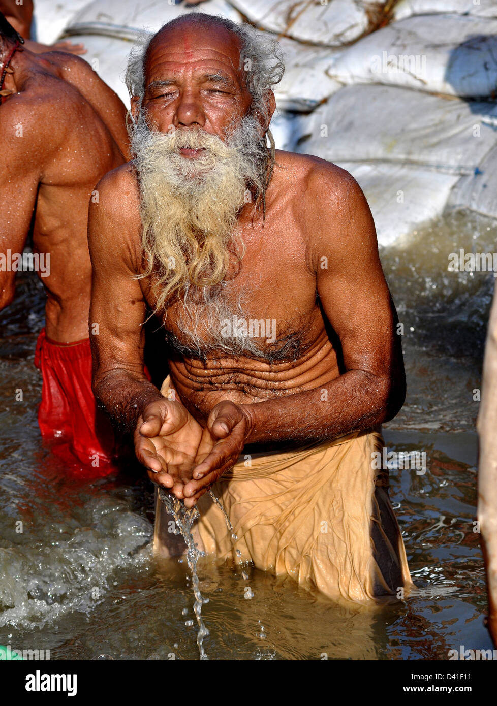 Ein Hindu Anhänger betet als Baden im Sangam oder Zusammenfluss der Yamuna und mythischen Saraswati Fluß Ganges Stockfoto