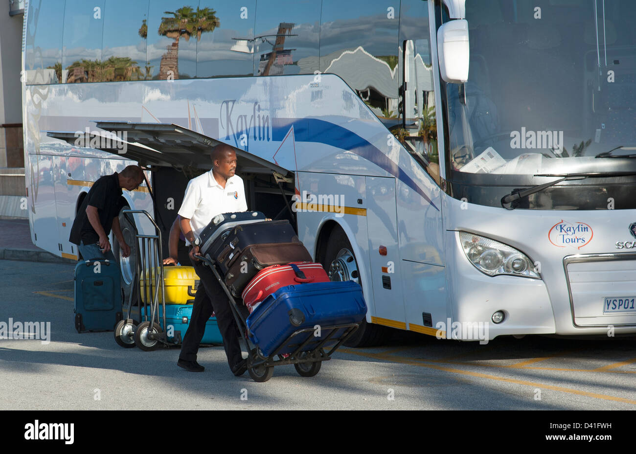 Porter mit Gastes Koffer auf einem Wagen. Entladung von einem Tour-Bus in Südafrika Stockfoto