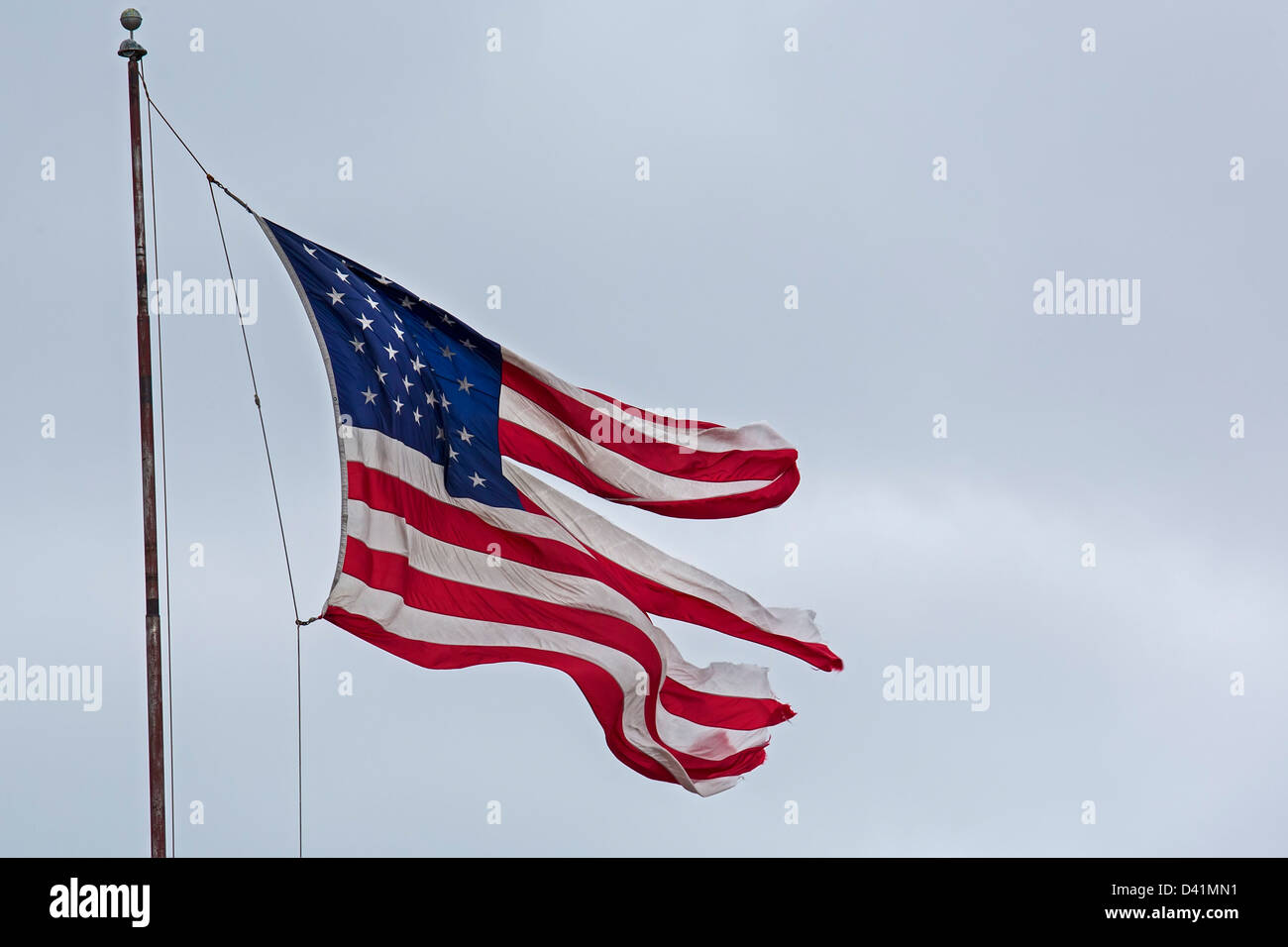 Detroit, Michigan - überfliegt eine zerfetzte Fahne ein Geschäft auf Detroits Ostseite. Stockfoto