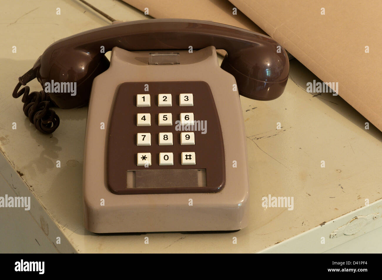 Eine zweifarbige grauen Druckknopf GPO 8782R Telefon. Im Jahr 1983 von Plessey gemacht. Ruht auf Büro Aktenschrank. Stockfoto