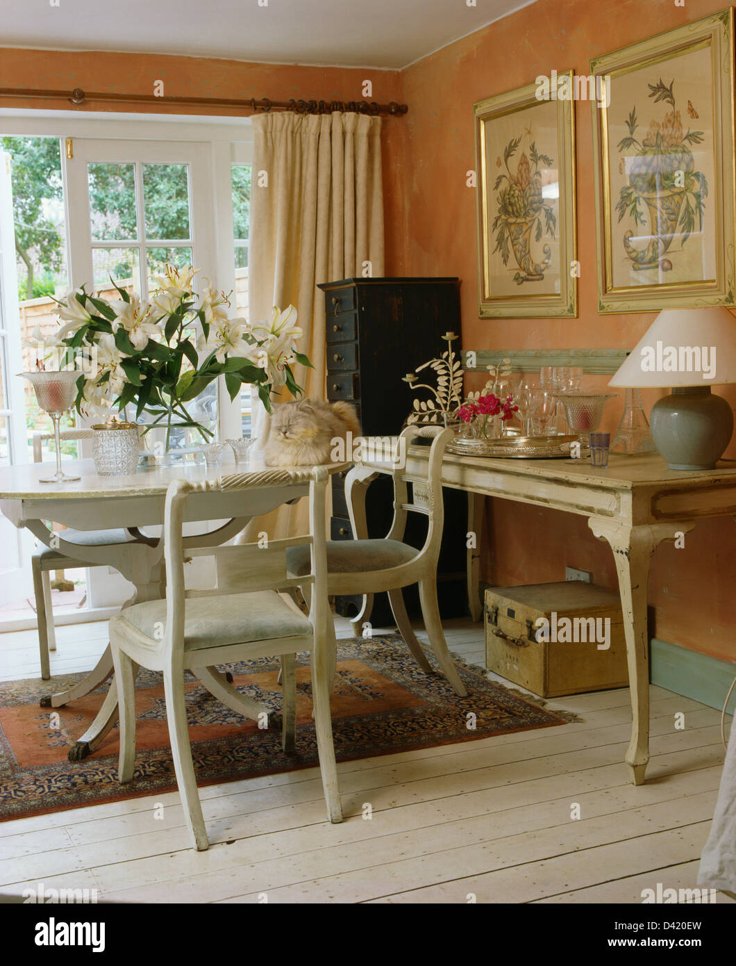 Weiss lackiert, Tisch und Stühle im Pfirsich Cottage Esszimmer mit Creme lackiert Konsolentisch Stockfoto