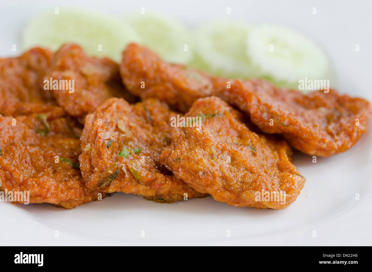 Würzig gebratene Fisch Kuchen mit Gurke auf Teller serviert Stockfoto