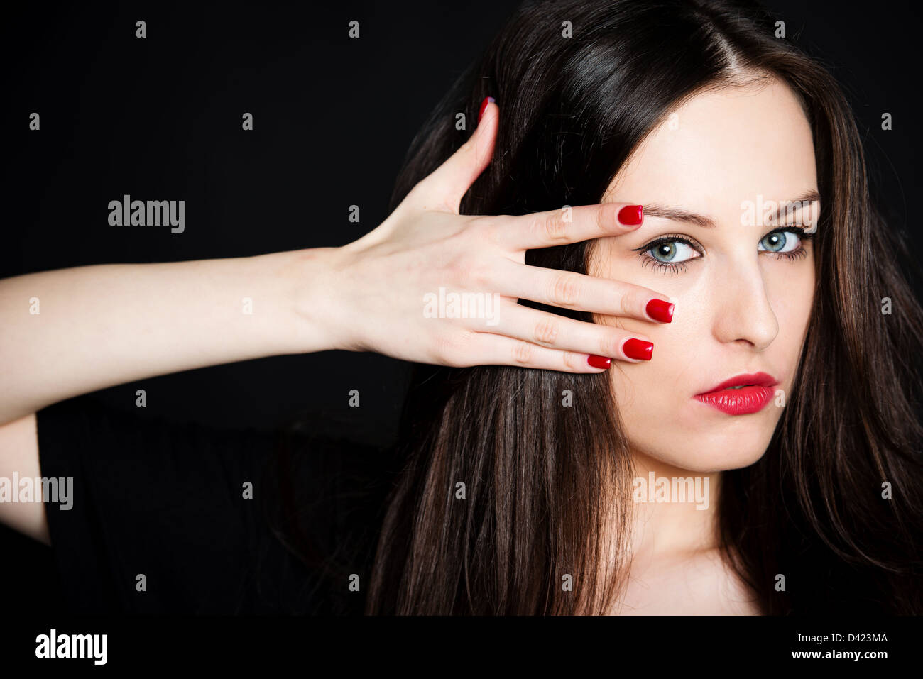 Fashion Portrait schöne Brünette mit roten Nägel und Lippen auf schwarzem Hintergrund Stockfoto