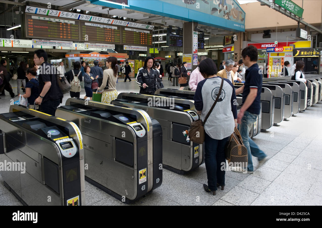 Pendler auf der Durchreise elektronische Einlasspforten auf ihrem Weg an die Bahnsteige im Bahnhof Ueno, Tokio. Stockfoto