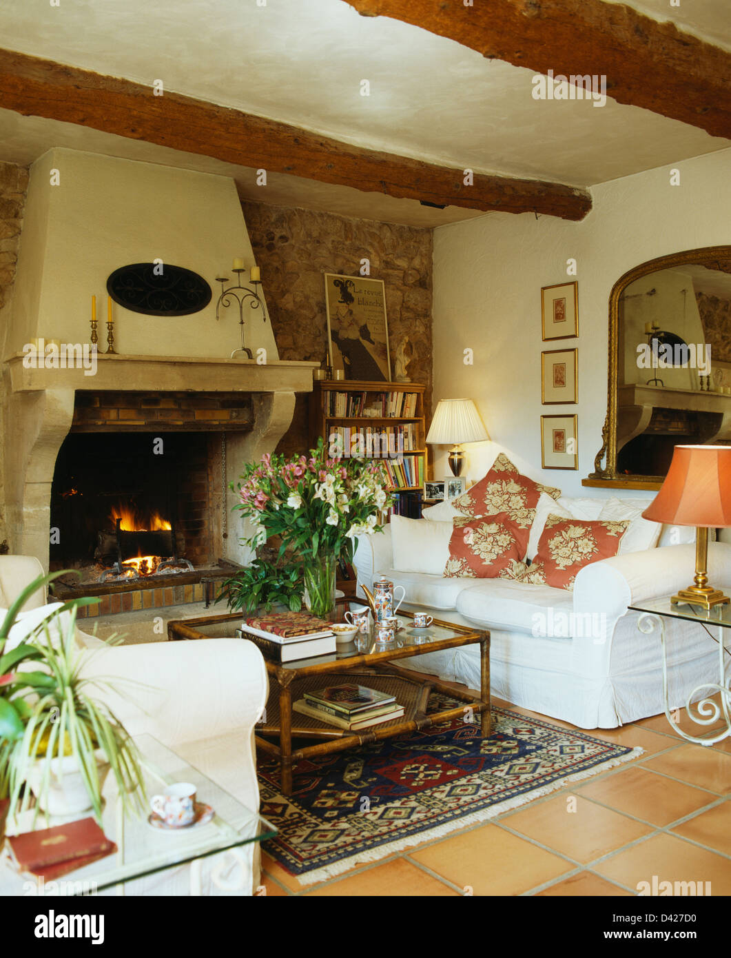 Weisse Sofas Auf Beiden Seiten Des Couchtisches Vor Grossen Kamin Mit Angezundeten Feuer In Franzosischer Landhaus Wohnzimmer Stockfotografie Alamy