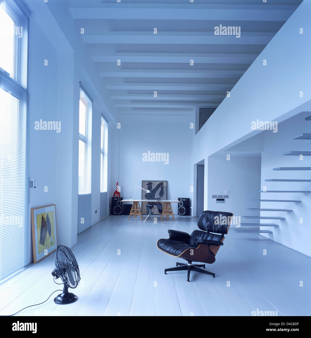 Charles Eames schwarzen no.671 Lounge Chair und Ventilator in Loft Conversion Halle mit lackierten Parkettboden und Deckenbalken Stockfoto