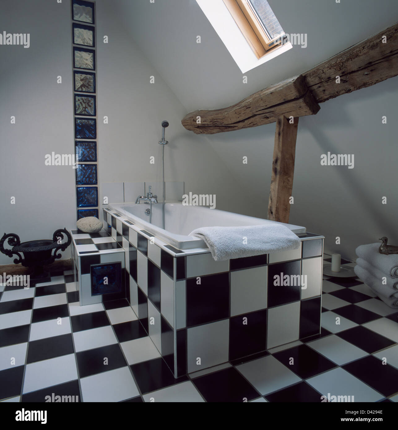 Schwarz / weiß Fliesen Boden und Bad-Panel im Dachgeschoss Badezimmer mit  rustikalen Holzbalken Stockfotografie - Alamy