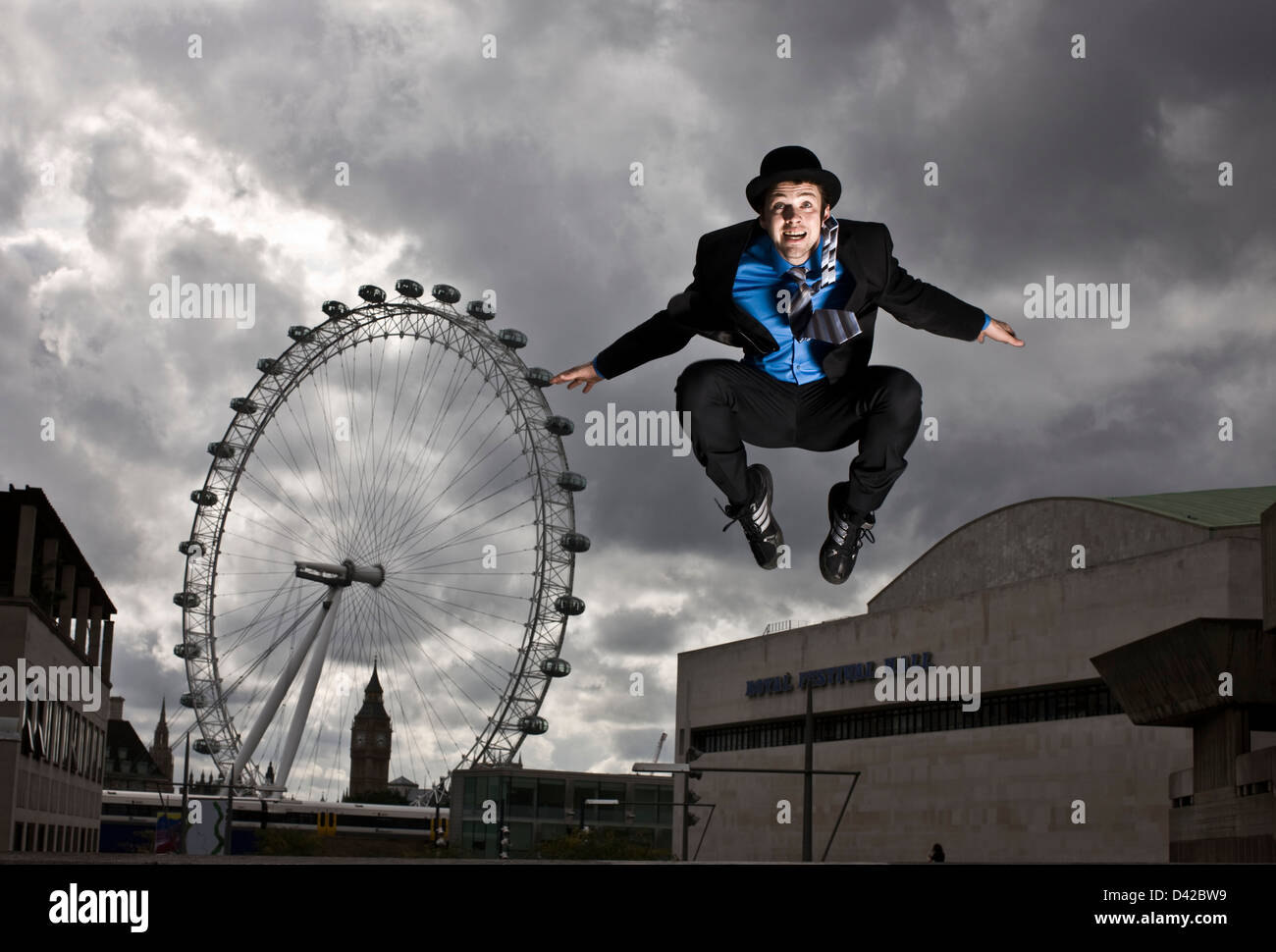 Parkour-Läufer in vollständigen Anzug springen vor London eye Stockfoto