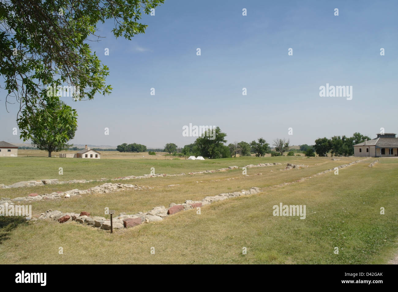 Blauer Himmelsblick, neue Wache, grüne Gras Ruinen alte Kaserne, Ostseite Exerzierplatz, Fort Laramie, Wyoming, USA Stockfoto