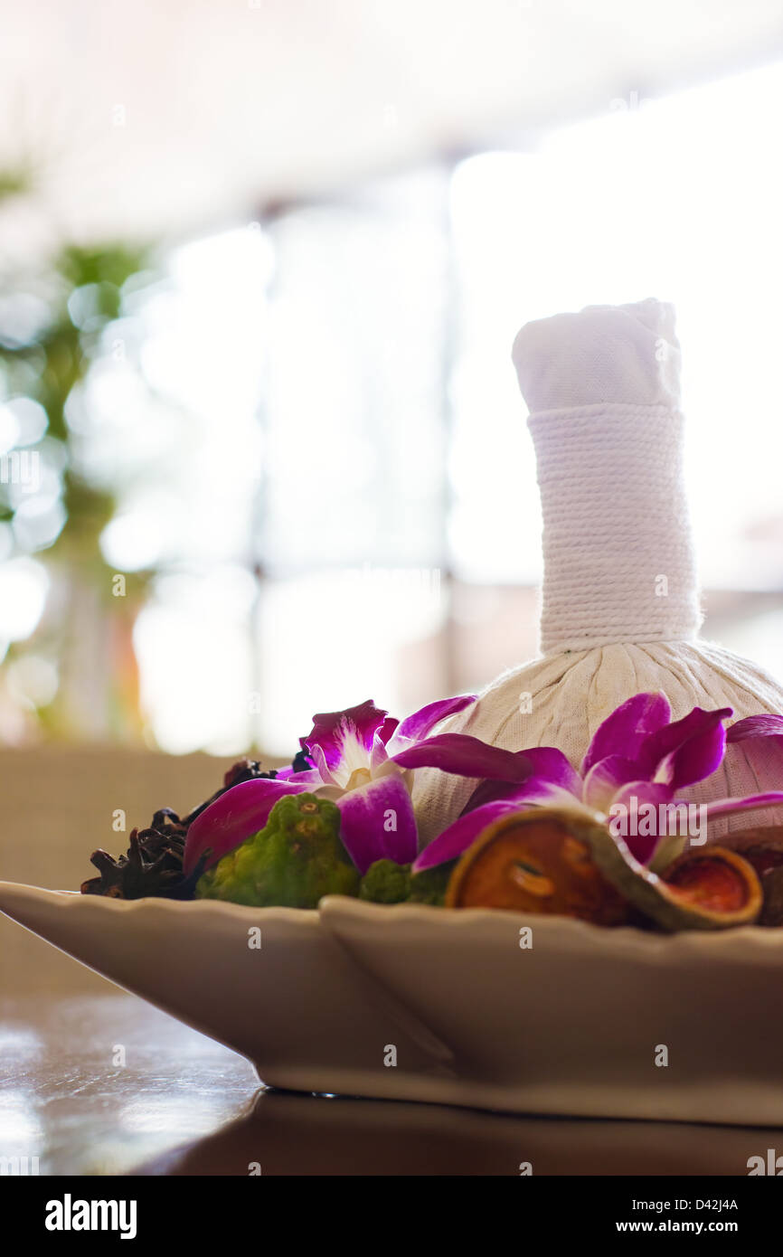 Thai-Spa-Arrangement für Massage. Kräuter-Tasche, Orchideen, Dekor. Vertikale stützte. Stockfoto