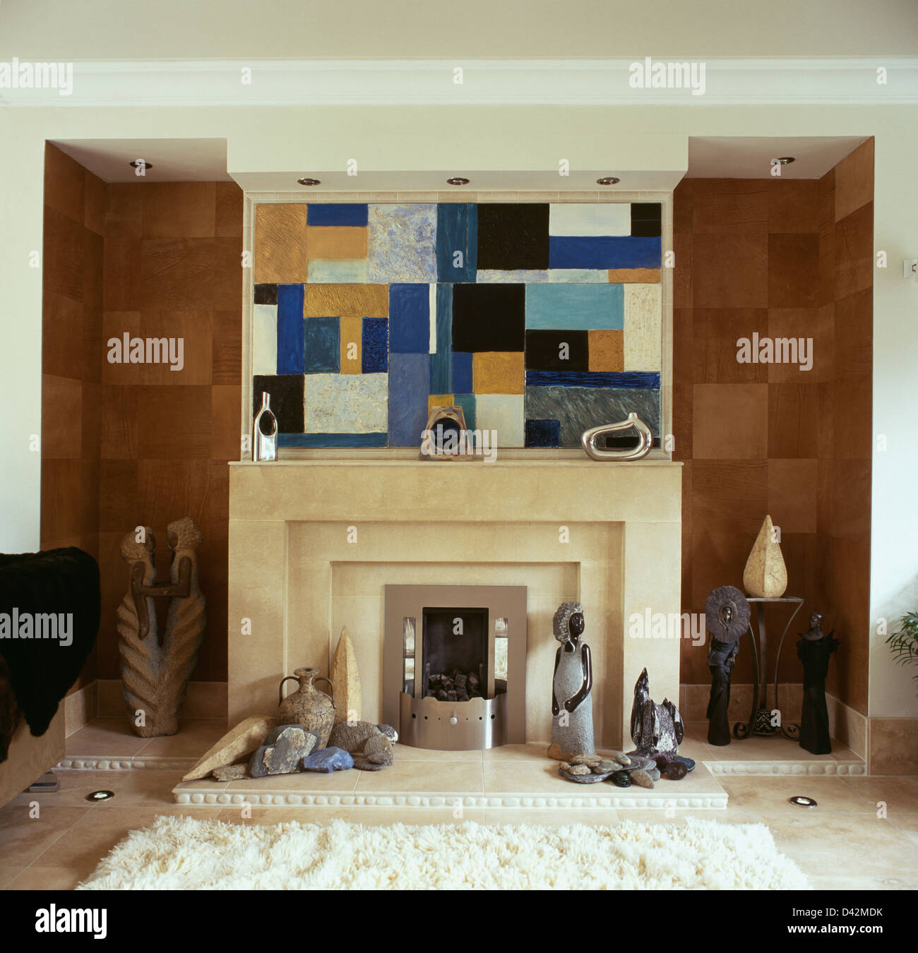 Braun gefliest Nischen auf beiden Seiten des Kamins unter abstrakten Malerei in moderne Wohnzimmer Stockfoto