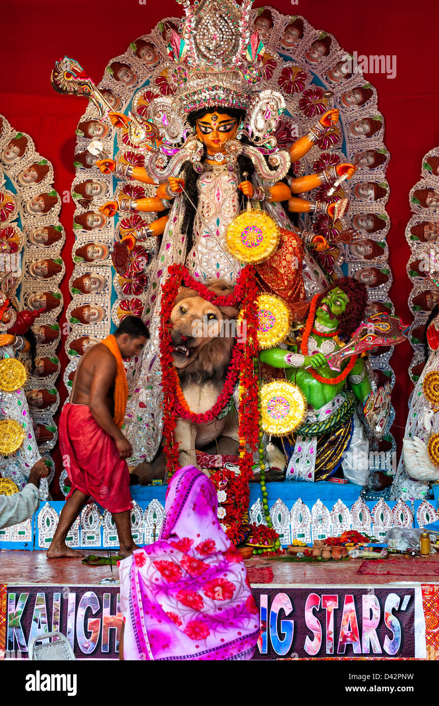 Eine Frau im Sari rundet ihre Puja an die Göttin Durga im, display, in der Nähe von Chowringhee, Kolkata, Indien während Durga Puja. Stockfoto