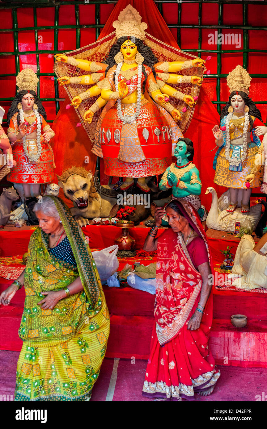 Zwei Frauen in Saris vervollständigen ihre Puja an die Göttin Durga Pandals, display, in der Nähe von Chowringhee, Kolkata, Indien während Durga Puja. Stockfoto