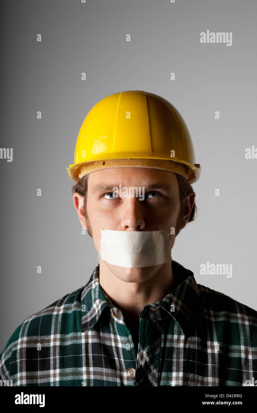 Freiburg, Deutschland, ein Handwerker mit Helm und Mund Zugeklebtem Bau im portrait Stockfoto