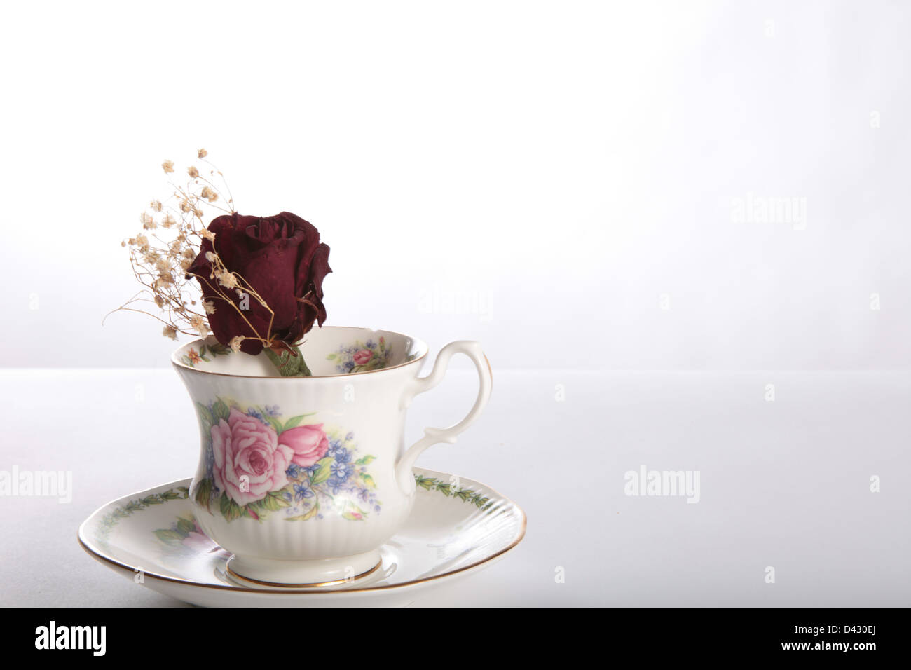 Getrocknete rote rose in eine Kaffeetasse Stockfoto