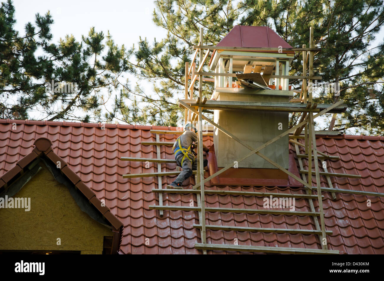 Arbeiter Männer mit Helm über Dach mit Ziegeln. Konstruktionsdetail Industrie. Stockfoto