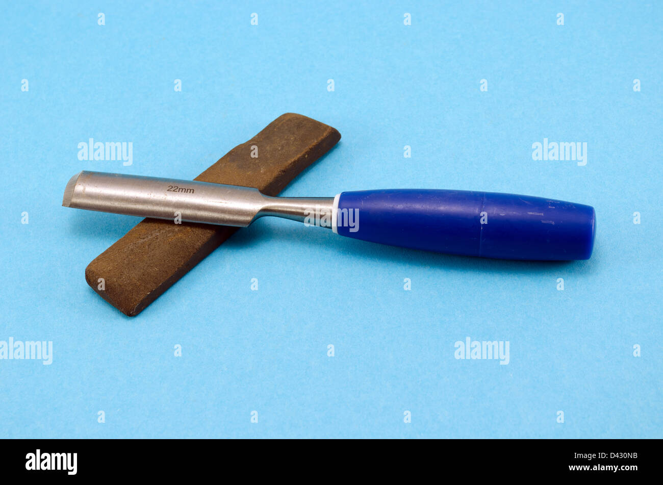 Meißel, Stichel schnitzen Werkzeug für Holz Arbeit und Schleifstein Stein auf blauem Hintergrund. Stockfoto