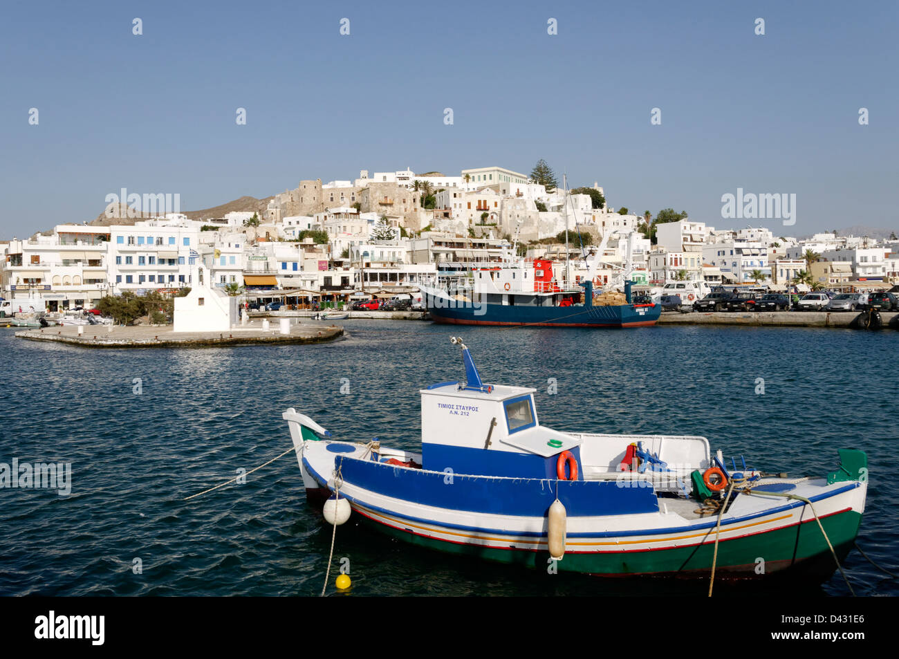 Naxos. Cyclades. Griechenland. Ein kleines angedockt Angelboot/Fischerboot im Hafen von Chora (Naxos-Stadt), der sich im Hintergrund erhebt. Stockfoto