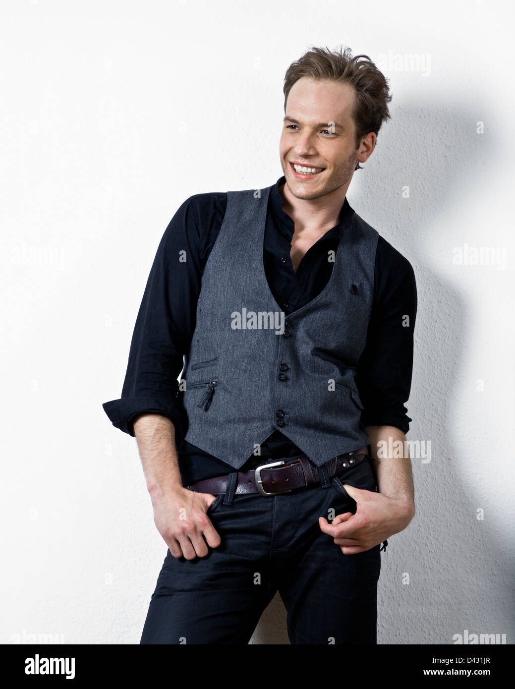 ein hübscher Männermodel kanalisieren den Geist der 80er Jahre. Hintergrundwand ist mit Textur Stockfoto