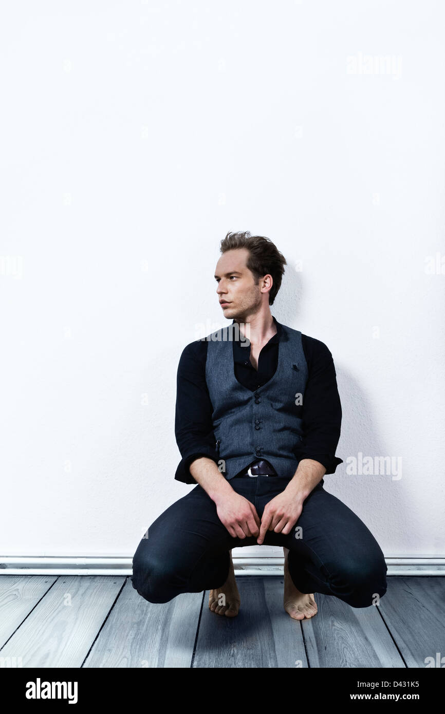 ein hübsches männliches Modell der 80er Jahre Gewand. Hintergrundwand ist mit Textur. Stockfoto