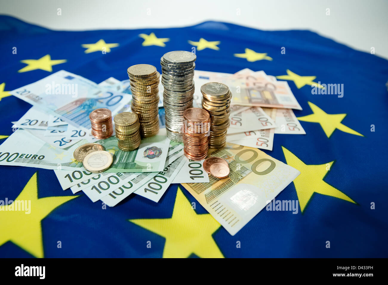 Hamburg, Deutschland, Euro-Banknoten und Euromuenzen auf eine europäische Flagge Stockfoto