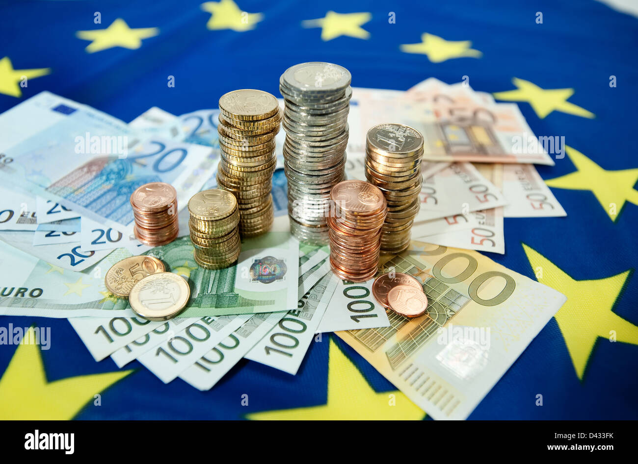 Hamburg, Deutschland, Euro-Banknoten und Euromuenzen auf eine europäische Flagge Stockfoto