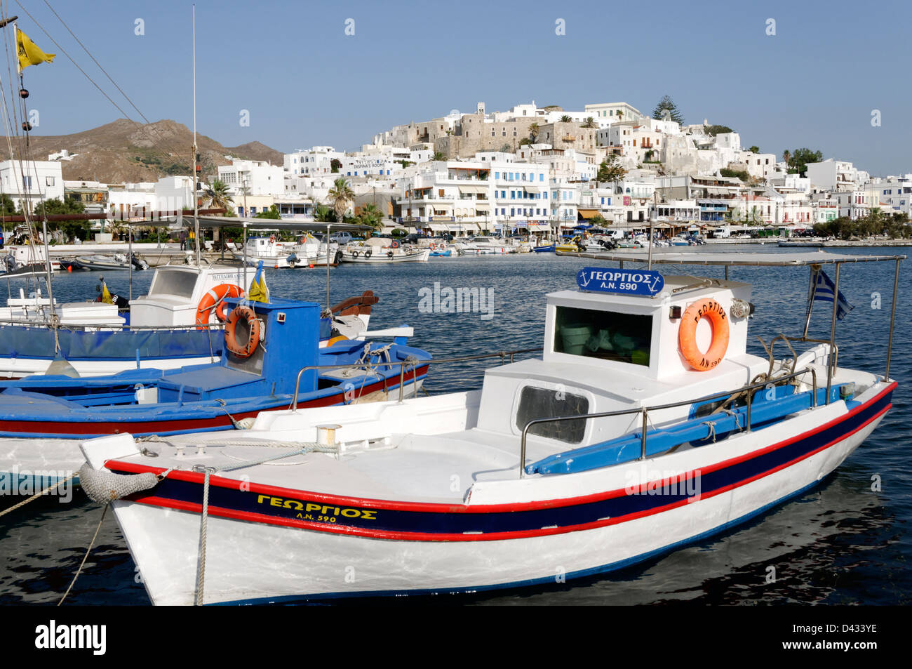 Naxos. Cyclades. Griechenland. Ein kleines angedockt Angelboot/Fischerboot im Hafen von Chora (Naxos-Stadt), die im Hintergrund steigt Stockfoto