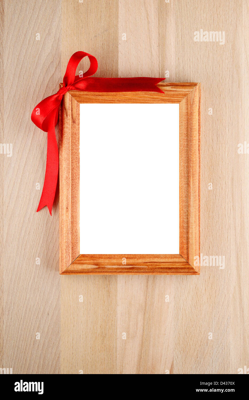 Fotorahmen mit roter Schleife auf Holz Stockfoto
