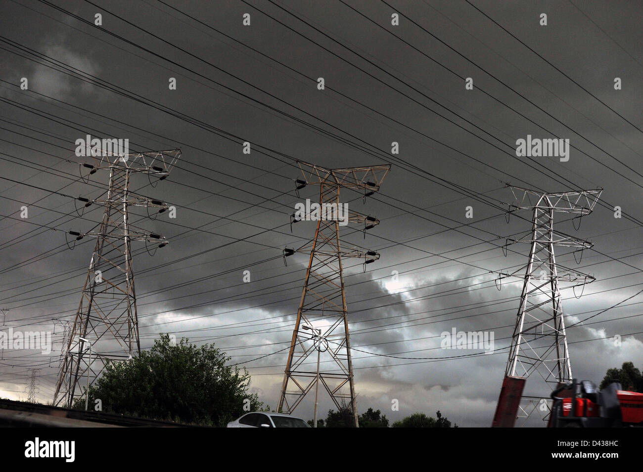 Ein Blick auf Strommasten mit einem dramatischen stürmischen Himmel im Hintergrund. Stockfoto