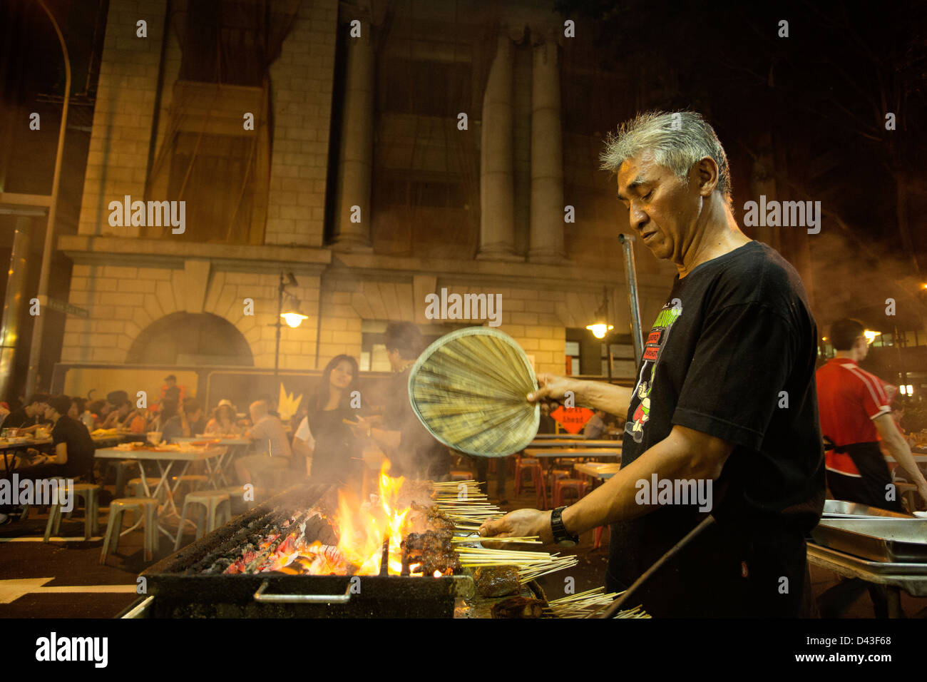 Singapur - 2013: Satay auf Lau Pa Sat Hawker Food Market Street. Satay-Chef fans seine Barbecue-Grill. Stockfoto