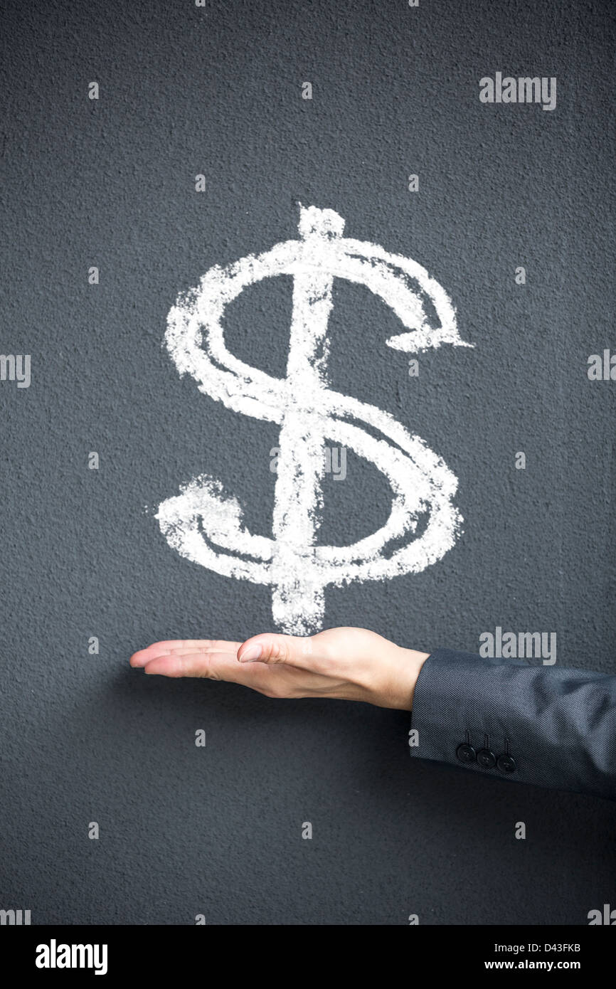 Business-Mann Hand vor Dollarzeichen auf eine Blackwall geschrieben. Konzept über Geld und Erfolg. Stockfoto