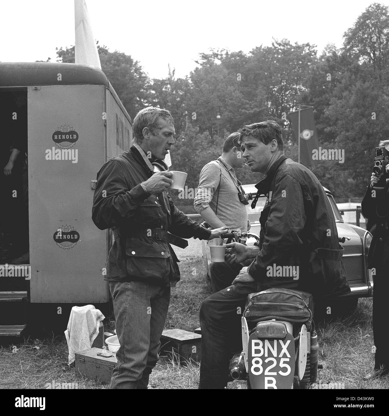 US-Schauspieler Steve McQueen (L) hat einen Kaffee während einer Erholungsphase, wie er in der internationalen Motorrad-Rennen "Six Days' on seinen Triumph mit der Nummer 278" in Erfurt, Deutsche Demokratische Republik (DDR) 1964 teilnahm. Fahrer und Motorräder der Marke DDR MZ waren erstklassige Produkte in den Motorrad Wettbewerben der 1960er Jahre. Foto. Dieter Demme Stockfoto