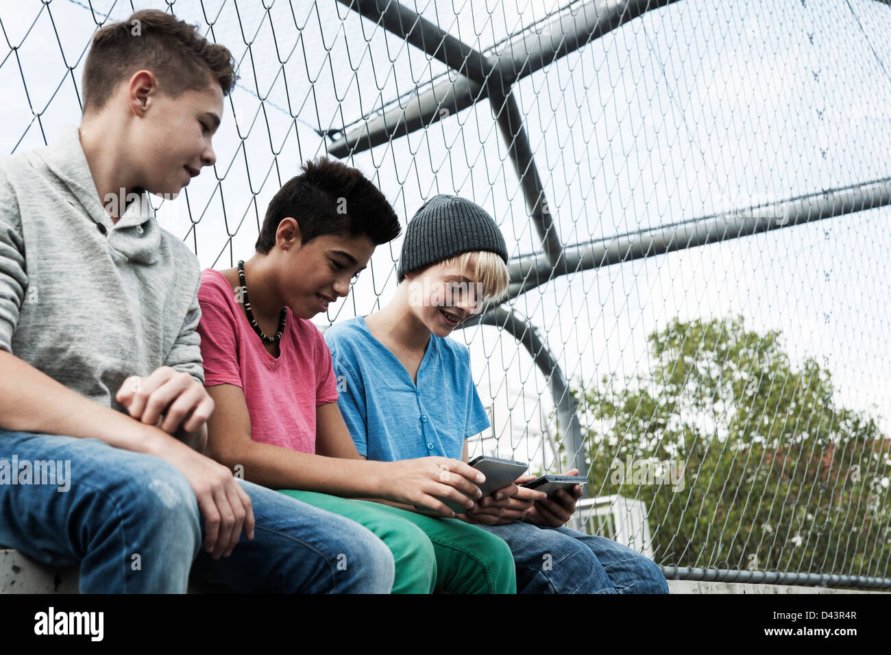 Drei jungen spielen von Videospielen in Spielplatz, Mannheim, Baden-Württemberg, Deutschland Stockfoto