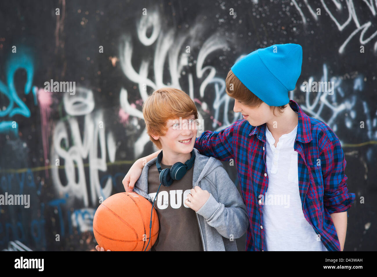 Jungen mit Basketball durch Graffiti bedeckt Wand, Mannheim, Baden-Württemberg, Deutschland Stockfoto