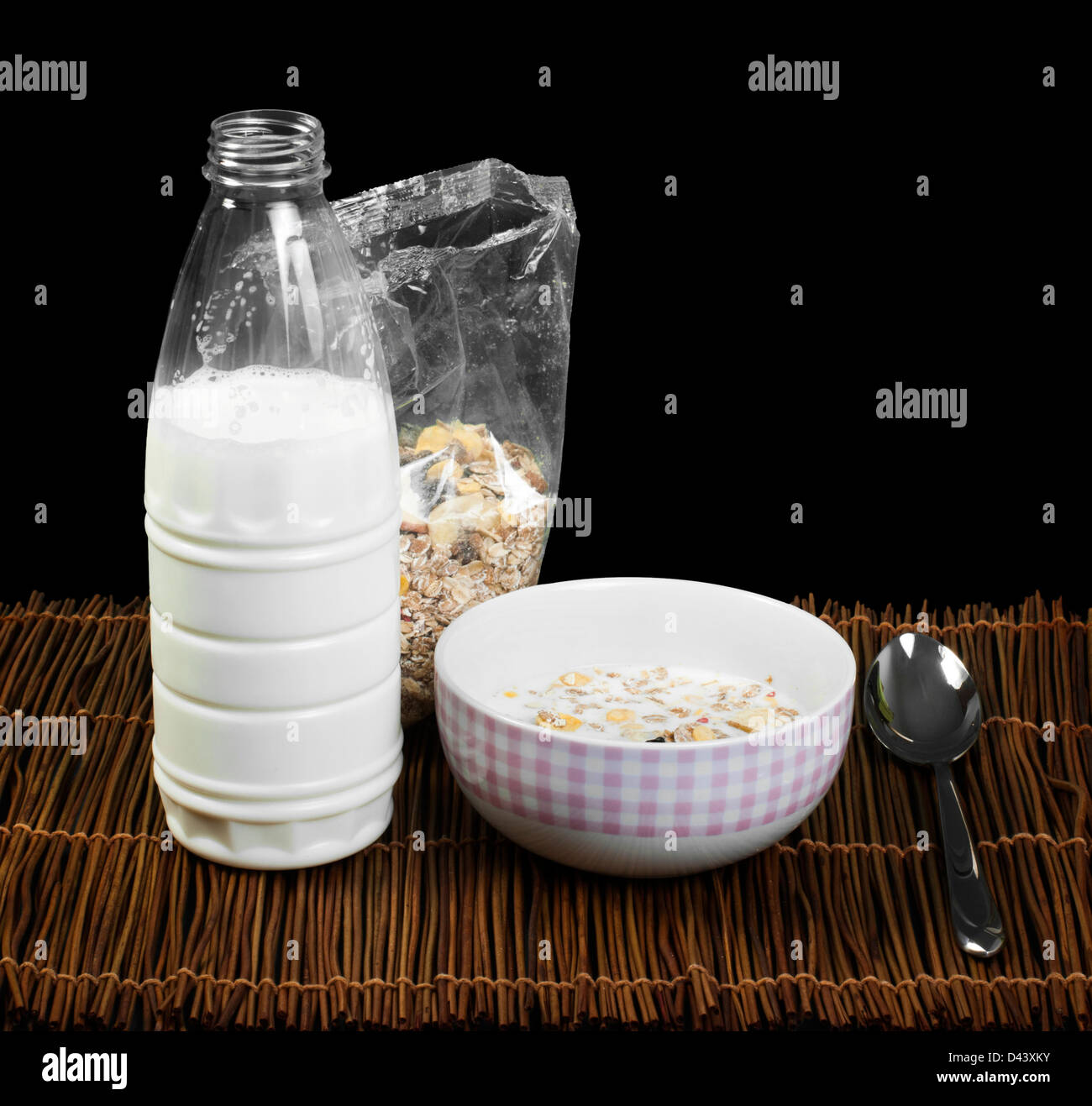 Müsli-Frühstück in transparenter Verpackung. Löffel, Schüssel und Milch. Stockfoto