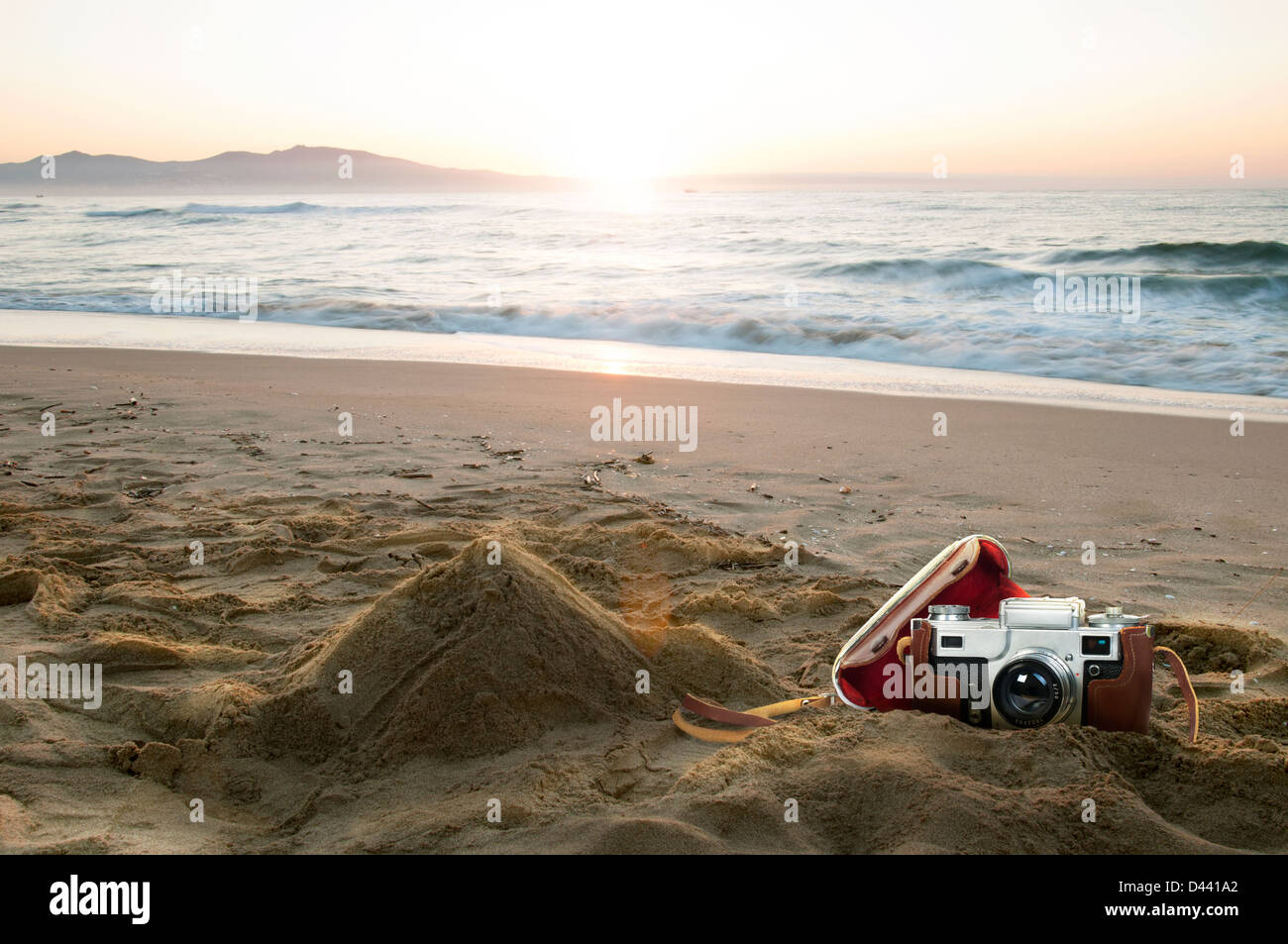 Vintage-Kamera am Strand bei Sonnenaufgang Stockfoto