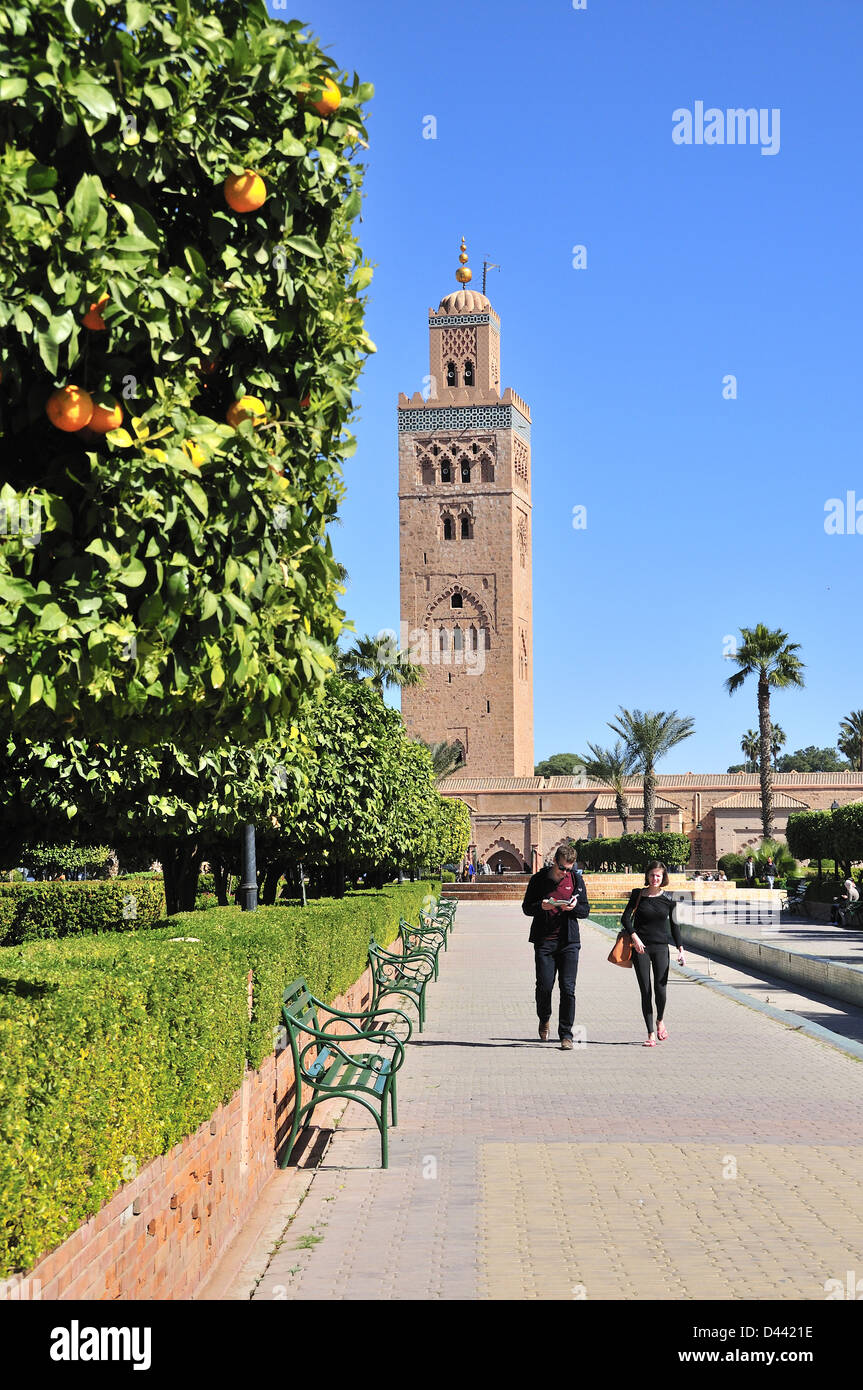 Minarett der Koutoubia-Moschee mit Touristen zu Fuß durch die Koutoubia Gärten, Marrakesch (Marrakech) Marokko Stockfoto