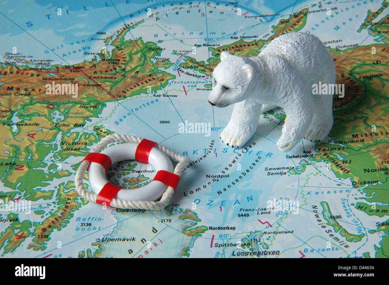 Illustration - sitzt eine Eisbär Miniatur Figur neben einer Miniatur-Sicherheit-Boje auf einer Karte in der Nähe des Nordpols in Berlin, Deutschland, 22. Dezember 2007. Foto: Berliner Verlag/S.Steinach Stockfoto
