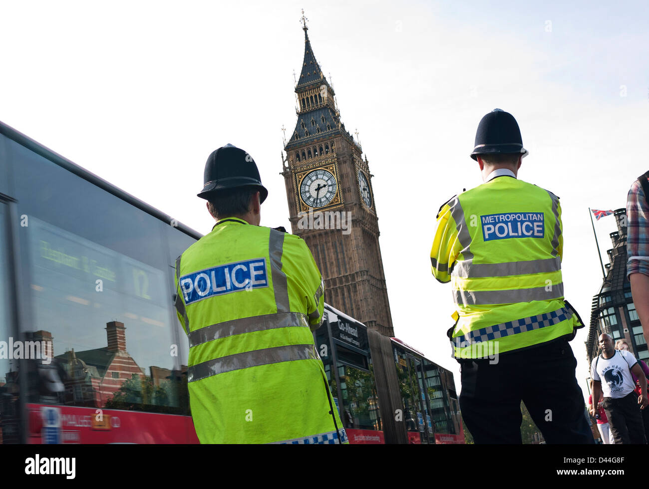 Londoner Polizeibeamte tragen Helme und gut sichtbare Jacken, Westminster Street Duty Rückansicht. Westminster Bridge Houses of Parliament London, Großbritannien Stockfoto