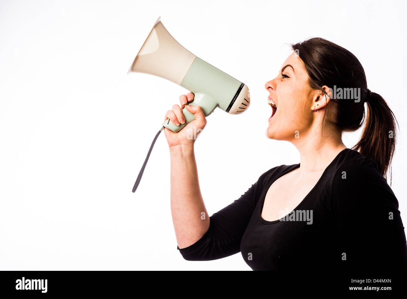 Eine junge Frau, braune Haare, schreien in ein Megaphon Lautsprechergehäuse UK Stockfoto