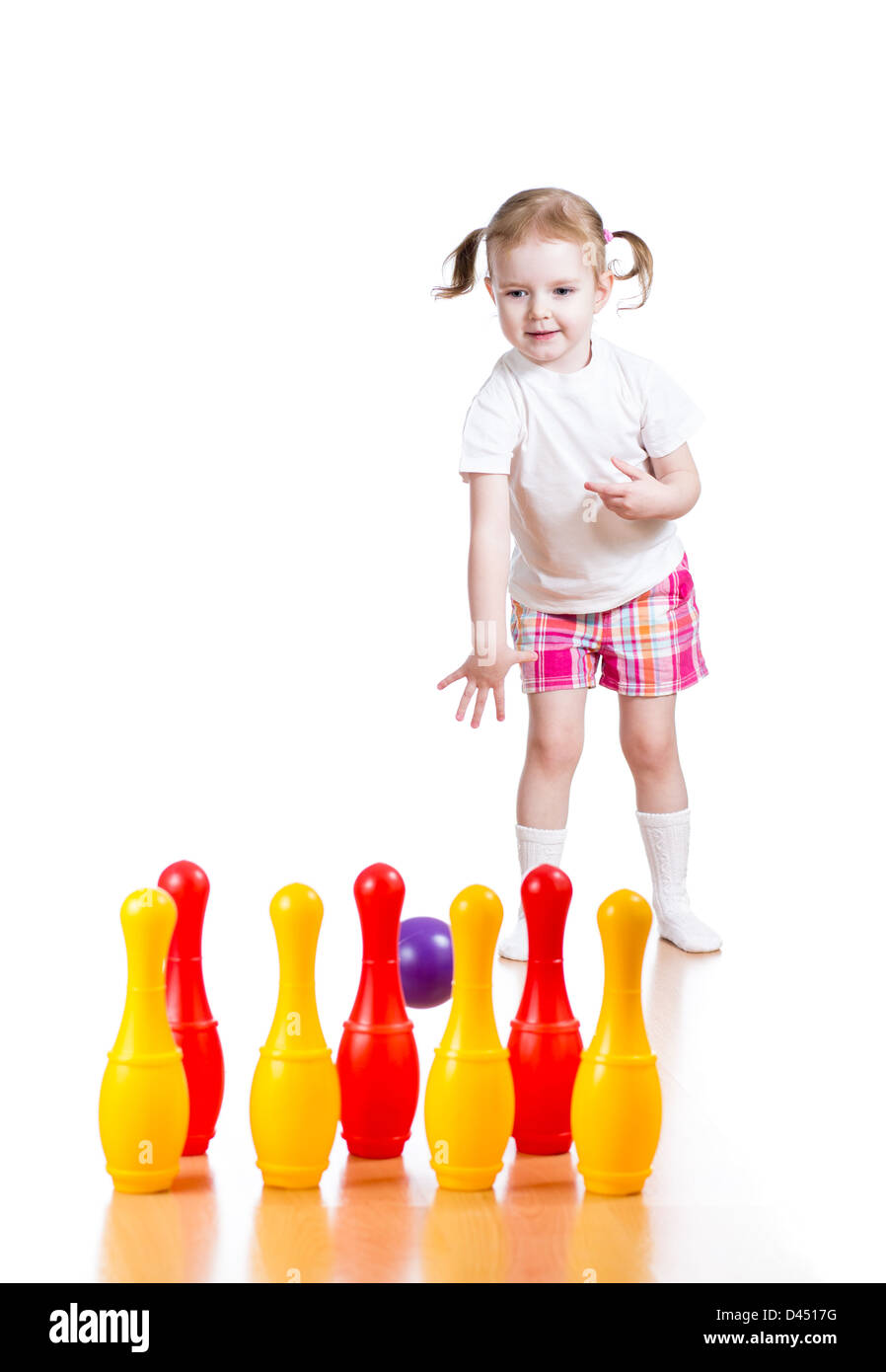 Kind Mädchen wirft Ball Spielzeug bowling-Pins abzureißen. Kind im Mittelpunkt. Stockfoto